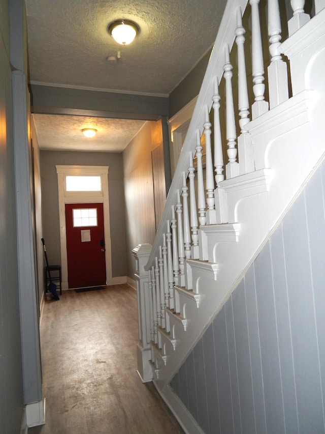 entryway with stairway, a textured ceiling, and baseboards