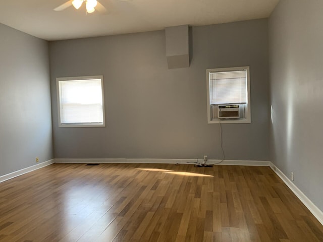 empty room featuring baseboards, dark wood finished floors, and cooling unit