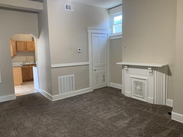 interior space with arched walkways, a sink, carpet flooring, and visible vents