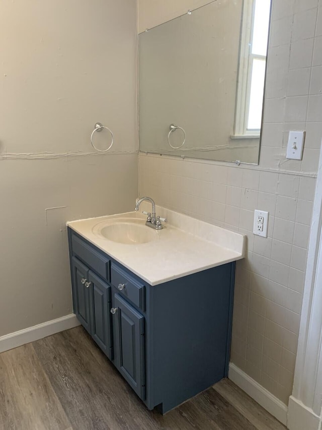 bathroom featuring tile walls, vanity, and wood finished floors