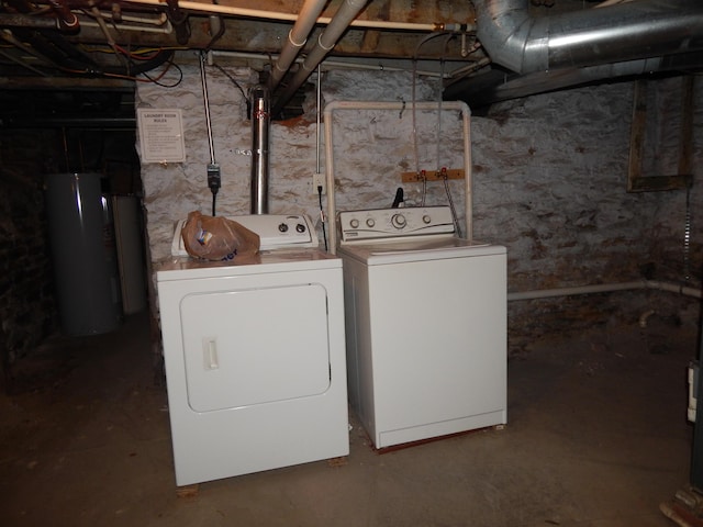 laundry room with laundry area, water heater, and washer and dryer