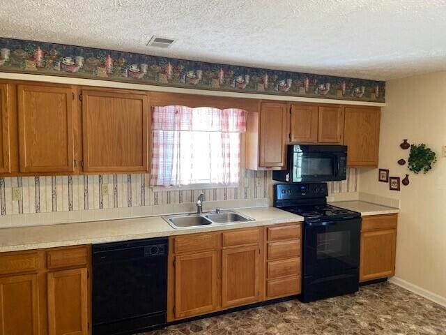 kitchen featuring brown cabinets, visible vents, a sink, a textured ceiling, and black appliances