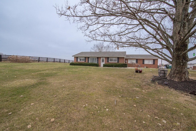 ranch-style house with brick siding, fence, and a front lawn