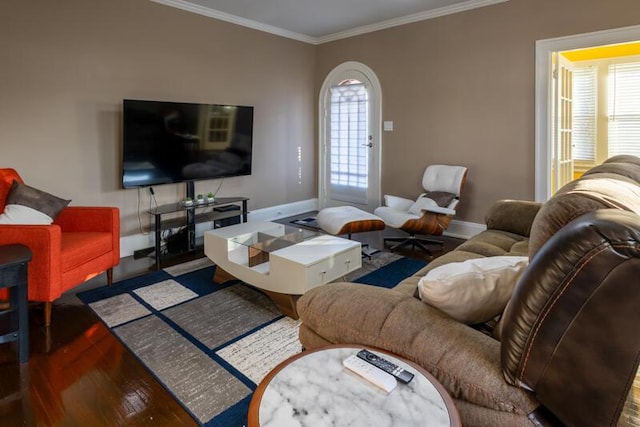 living room featuring crown molding, baseboards, and wood finished floors