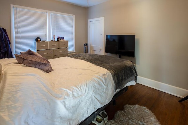 bedroom featuring baseboards and dark wood finished floors