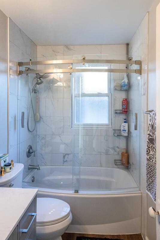 bathroom with vanity, toilet, and shower / bath combination with glass door