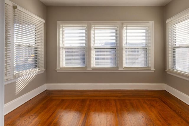 empty room featuring baseboards and hardwood / wood-style flooring