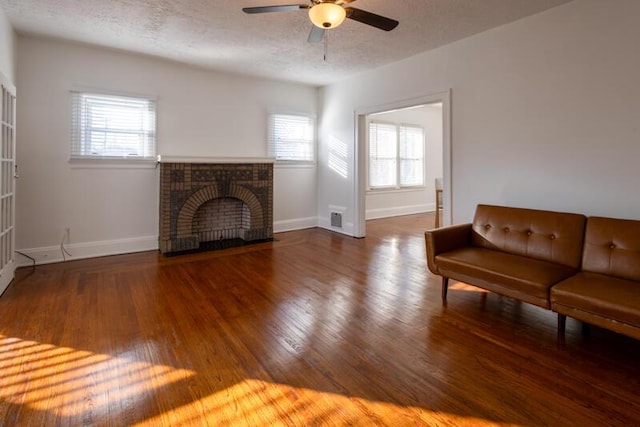 living room with baseboards, a textured ceiling, ceiling fan, and wood finished floors