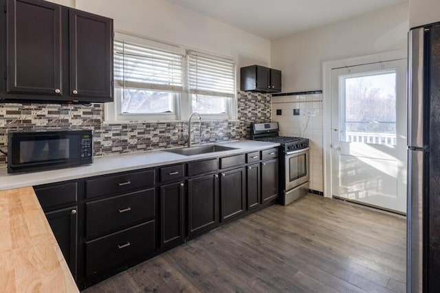 kitchen featuring a sink, light countertops, dark wood-style flooring, and stainless steel appliances