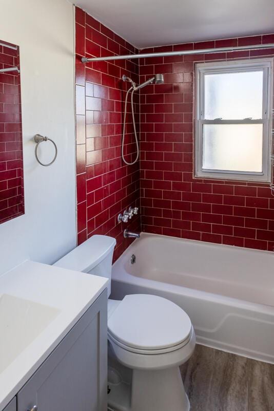 bathroom featuring vanity, toilet, wood finished floors, and shower / bathtub combination