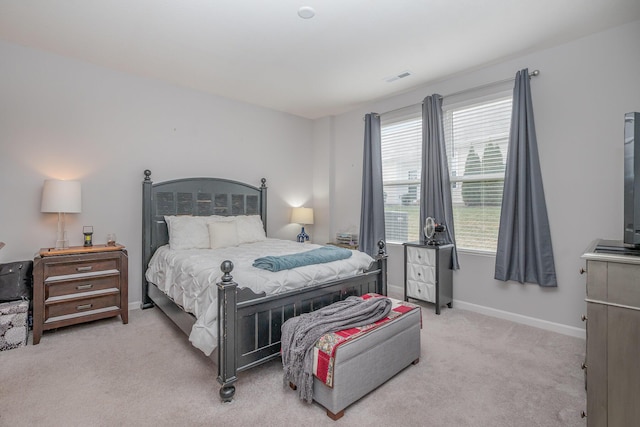 bedroom featuring baseboards, visible vents, and light colored carpet