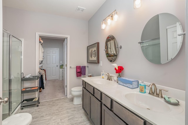 full bathroom with visible vents, a sink, a shower stall, and toilet