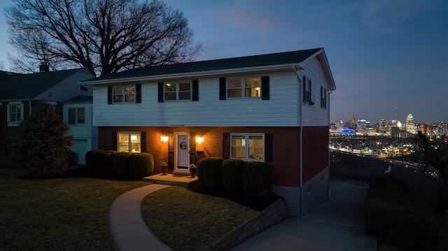 view of front of home with a front yard and brick siding