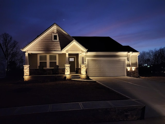 craftsman house with an attached garage, stone siding, a porch, and concrete driveway