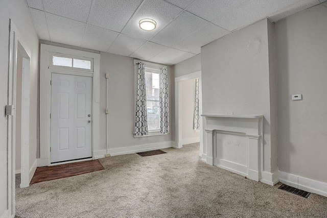 carpeted entrance foyer featuring a drop ceiling, visible vents, and baseboards