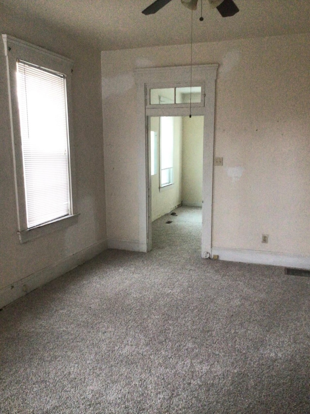 unfurnished room with ceiling fan and carpet flooring