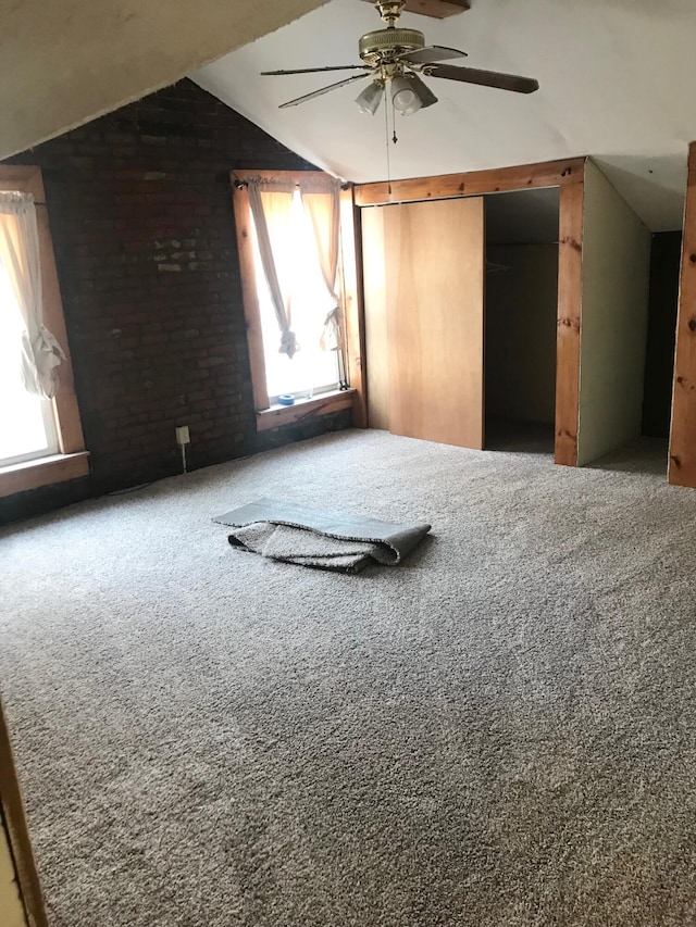 unfurnished room with carpet, vaulted ceiling, and ceiling fan