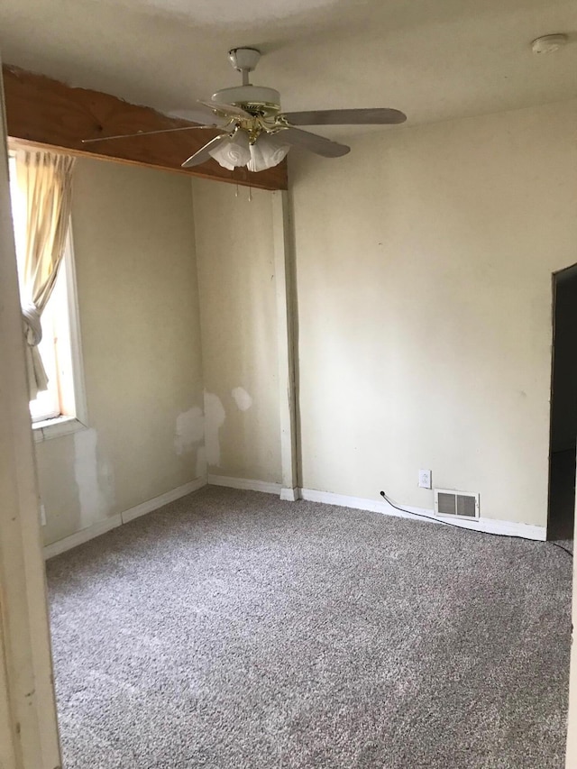 spare room with baseboards, carpet flooring, visible vents, and a ceiling fan