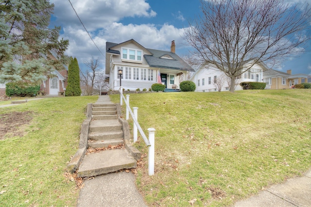 view of front of home with a chimney and a front yard