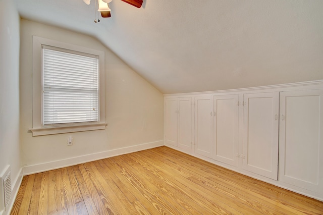 bonus room featuring visible vents, light wood-style floors, vaulted ceiling, ceiling fan, and baseboards