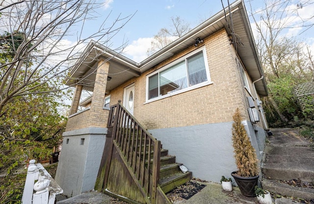 view of home's exterior with stairway and brick siding