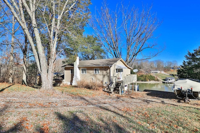 view of property exterior featuring a water view and a chimney