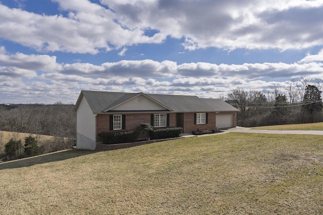 ranch-style home with a garage, a front yard, brick siding, and driveway