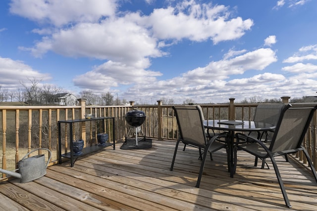 wooden deck with outdoor dining area and area for grilling