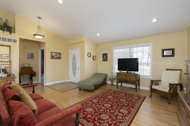 living room with lofted ceiling, recessed lighting, visible vents, and light wood-style floors