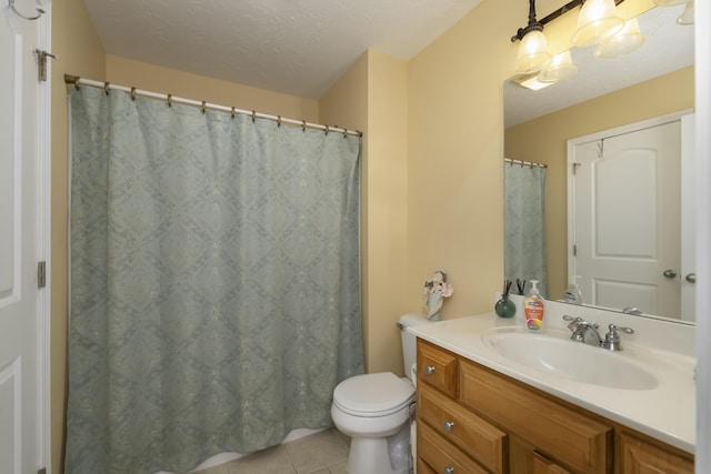 bathroom with toilet, a textured ceiling, vanity, and tile patterned floors