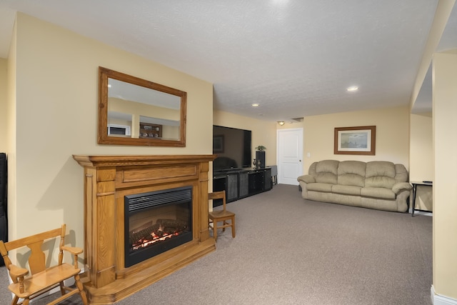 living area featuring a glass covered fireplace, a textured ceiling, carpet, and recessed lighting