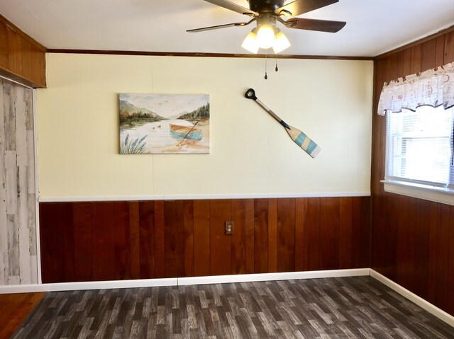 unfurnished room featuring ornamental molding, wainscoting, wood walls, and wood finished floors