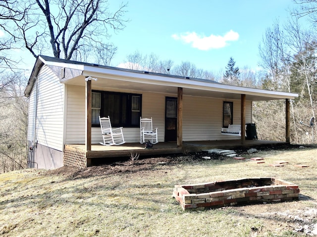 view of front facade featuring covered porch and a fire pit