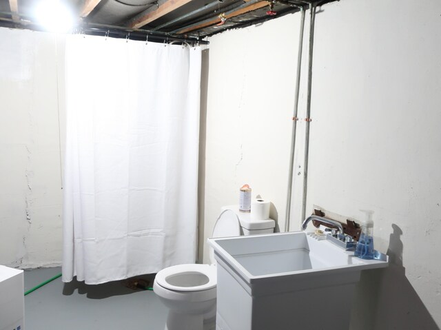 bathroom featuring curtained shower, vanity, toilet, and finished concrete floors