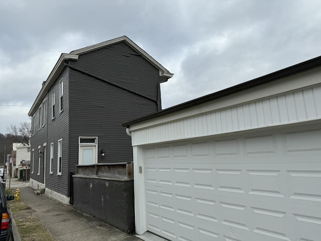 view of side of property with a garage and driveway