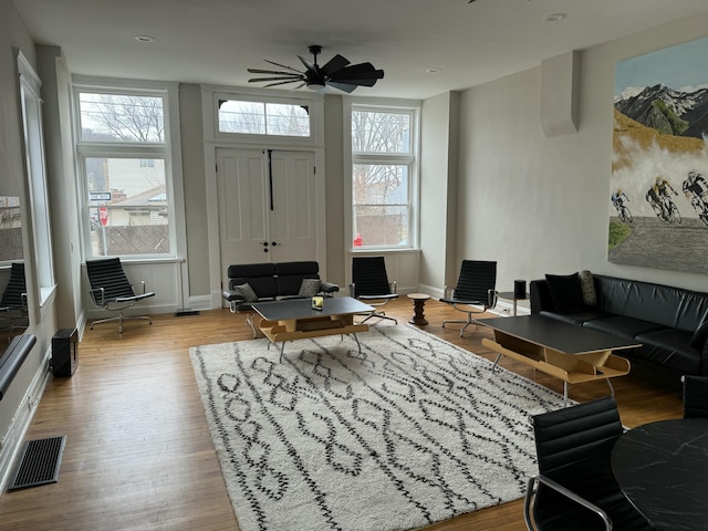 living room with a wealth of natural light, baseboards, visible vents, and wood finished floors