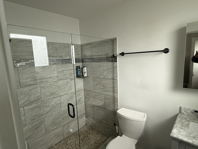 full bath featuring a stall shower, vanity, and toilet