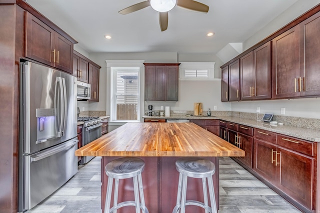 639 Watkins St, Covington, KY 41011 - kitchen with appliances with stainless steel finishes, butcher block countertops, a ceiling fan, light wood-style flooring, and recessed lighting