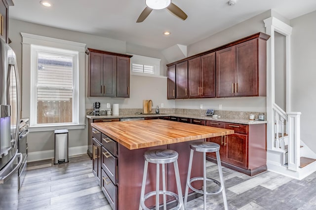 639 Watkins St, Covington, KY 41011 - kitchen featuring butcher block counters, stainless steel fridge, light wood-style flooring, ceiling fan, and a breakfast bar