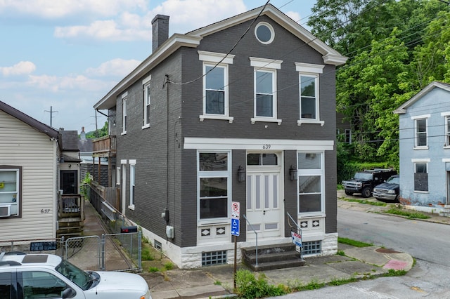 639 Watkins St, Covington, KY 41011 - shotgun-style home with brick siding, a chimney, a gate, and entry steps