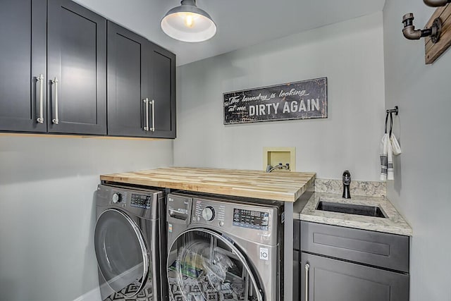 laundry area with washer and dryer, cabinet space, and a sink