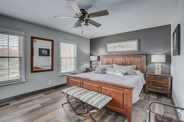 bedroom with visible vents, ceiling fan, baseboards, and wood finished floors