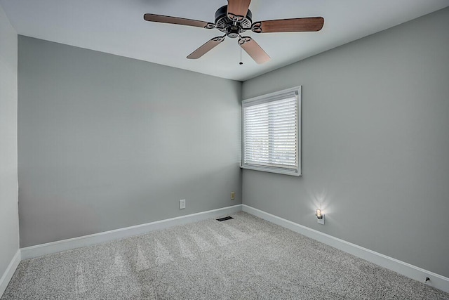 carpeted empty room with visible vents, a ceiling fan, and baseboards