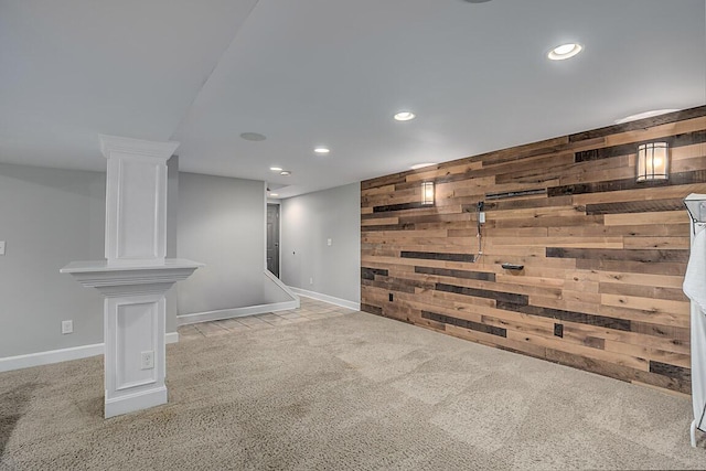 finished below grade area featuring baseboards, recessed lighting, wood walls, an accent wall, and carpet flooring