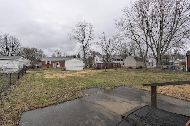 view of yard featuring a fenced backyard, a residential view, an outbuilding, a patio area, and a shed