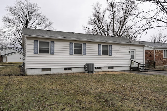 back of house with entry steps, fence, central AC, and a yard