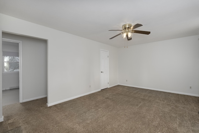 carpeted spare room with baseboard heating, ceiling fan, and baseboards