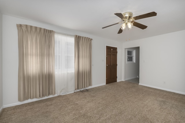 empty room featuring carpet, ceiling fan, and baseboards