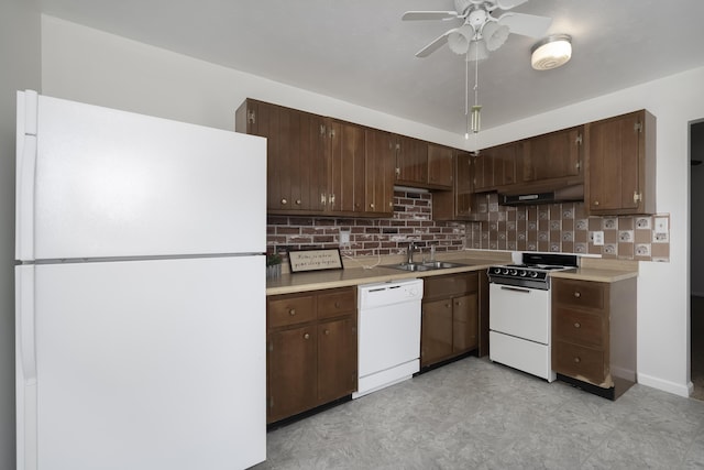 kitchen with under cabinet range hood, white appliances, a sink, light countertops, and backsplash