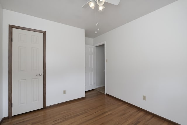 unfurnished bedroom with ceiling fan, baseboards, and wood finished floors